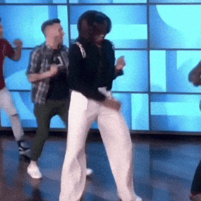 A Group Of People Are Dancing In Front Of A Blue Wall . GIF