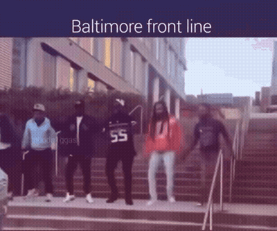 A Group Of People Are Dancing In Front Of A Building And The Words Baltimore Front Line Are Above Them GIF
