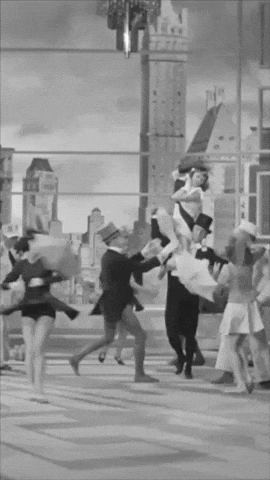 A Group Of People Are Dancing In Front Of A Building GIF
