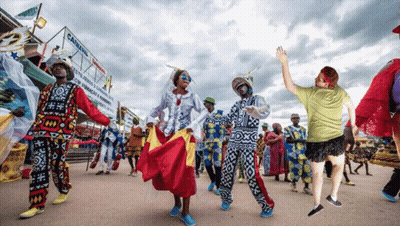 A Group Of People Are Dancing In Front Of A Canning Sign GIF