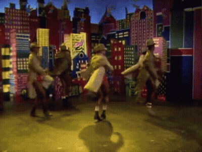 A Group Of People Are Dancing In Front Of A Cityscape With A Sign That Says Disco GIF