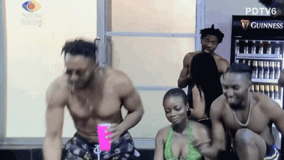 A Group Of People Are Dancing In Front Of A Guinness Cooler GIF