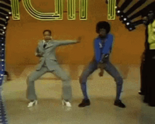 A Group Of People Are Dancing In Front Of A Neon Sign . GIF