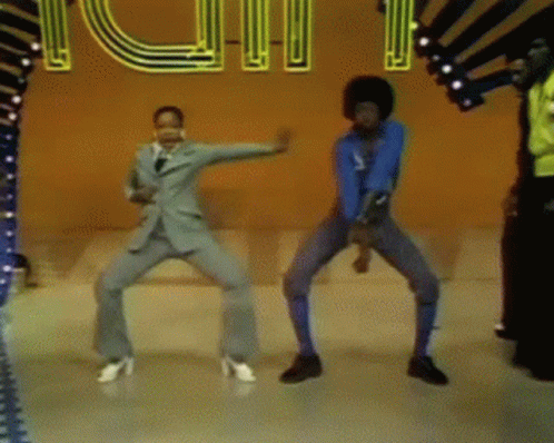 A Group Of People Are Dancing In Front Of A Neon Sign That Says ' Rhythm ' On It GIF