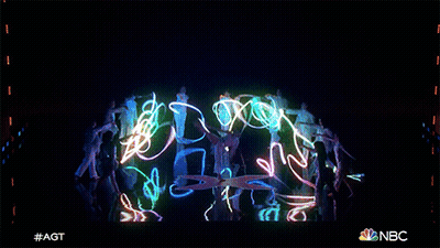 A Group Of People Are Dancing In Front Of A Screen That Says Nbc On It GIF