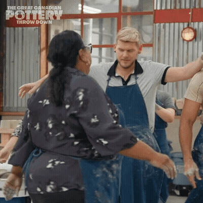 A Group Of People Are Dancing In Front Of A Sign For The Great Canadian Pottery Throw Down GIF