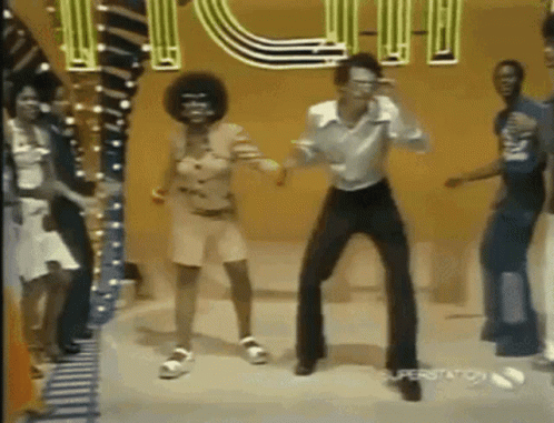 A Group Of People Are Dancing In Front Of A Sign That Says ' Superstation ' On It GIF