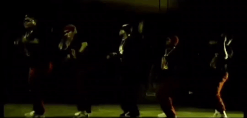A Group Of People Are Dancing In The Dark In A Dark Room . GIF