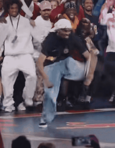 A Group Of People Are Dancing On A Basketball Court And One Of Them Is Wearing A Shirt That Says Nike On It GIF