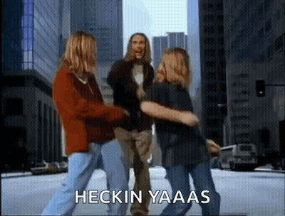 A Group Of People Are Dancing On A City Street With The Words Heckin Yaaas Written On The Bottom . GIF