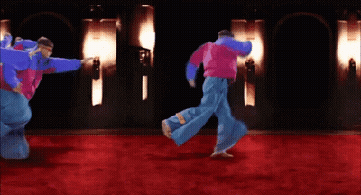 A Group Of People Are Dancing On A Red Carpet In A Dark Room GIF