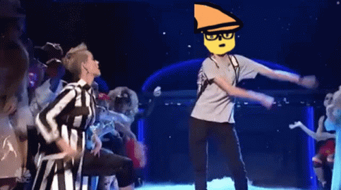 A Group Of People Are Dancing On A Stage And One Of Them Has A Yellow Face On His Head . GIF