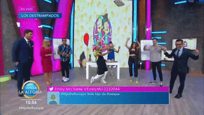 A Group Of People Are Dancing On A Stage In Front Of A Sign That Says En Vivo GIF