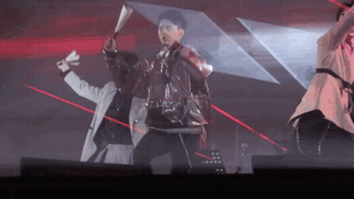 A Group Of People Are Dancing On A Stage With Red Lasers Behind Them . GIF