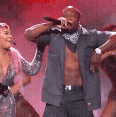 A Group Of People Are Dancing On A Stage With The Number 1 In The Middle GIF