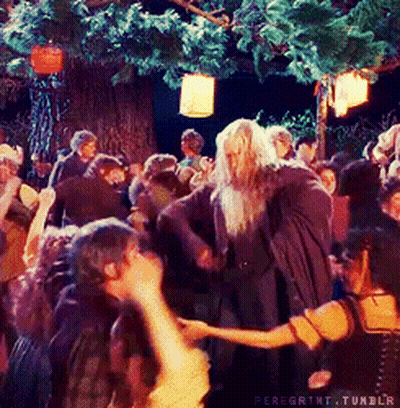 A Group Of People Are Dancing Under A Tree With Lanterns Hanging From It GIF