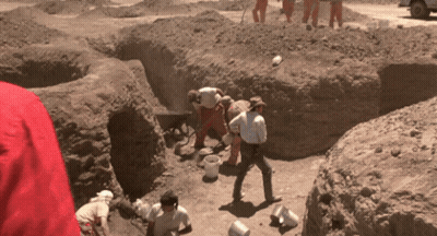 A Group Of People Are Digging In A Dirt Area GIF