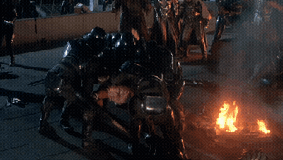 A Group Of People Are Fighting A Man In A Costume GIF