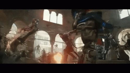 A Group Of People Are Fighting Each Other In A Room With A Fire Coming Out Of The Ceiling . GIF