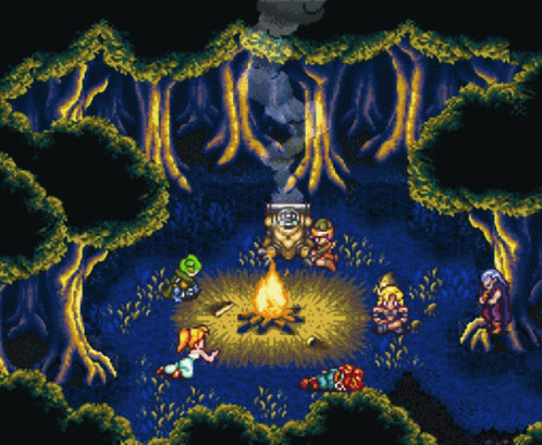 A Group Of People Are Gathered Around A Fire In The Middle Of A Forest GIF
