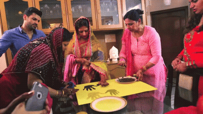 A Group Of People Are Gathered Around A Table With Plates And A Cell Phone GIF