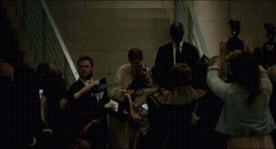 A Group Of People Are Gathered Around A Woman In A White Dress GIF