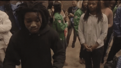 A Group Of People Are Gathered Around A Young Man In A Black Hoodie GIF