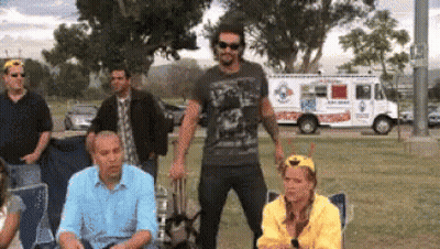 A Group Of People Are Gathered In A Park With An Ice Cream Truck Parked In The Background GIF