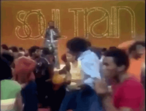 A Group Of People Are Gathered In Front Of A Sign That Says " Sultan " GIF