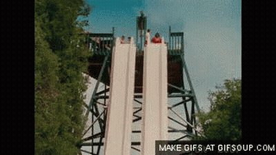 A Group Of People Are Going Down A Water Slide At A Theme Park GIF