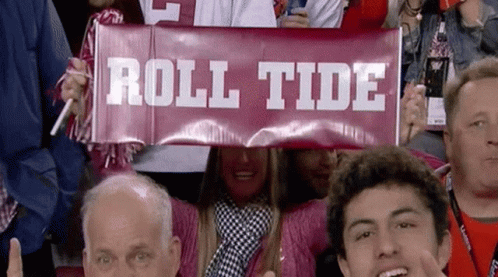 A Group Of People Are Holding Up A Sign That Says Roll Tide GIF