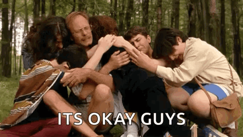 A Group Of People Are Hugging Each Other In A Circle . GIF