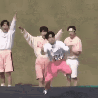 A Group Of People Are Jumping On A Trampoline And One Of Them Is Kneeling Down . GIF
