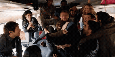 A Group Of People Are Laughing And Having Fun In A Room GIF