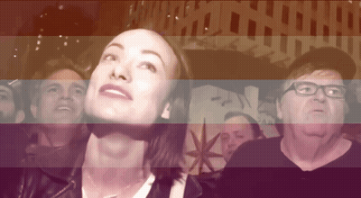 A Group Of People Are Looking Up At Something In Front Of A Sign That Says Pan GIF