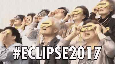 A Group Of People Are Looking Up At The Sky While Wearing Sunglasses . GIF