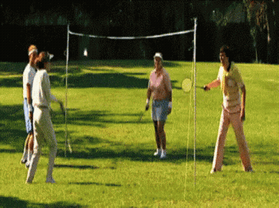 A Group Of People Are Playing A Game Of Badminton On A Lush Green Field GIF