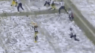 A Group Of People Are Playing A Game Of Football In The Snow On A Field . GIF