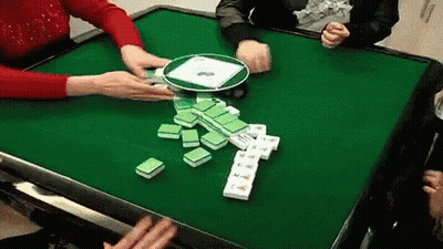 A Group Of People Are Playing A Game Of Mahjong At A Table . GIF