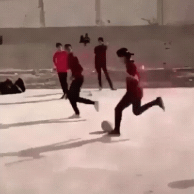 A Group Of People Are Playing A Game Of Soccer On A Ice Rink . GIF