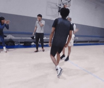 A Group Of People Are Playing Basketball On A Court And One Of Them Is Wearing A Black Shirt GIF