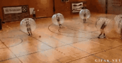 A Group Of People Are Playing Bubble Soccer On A Court GIF