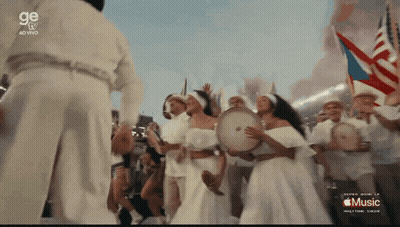 A Group Of People Are Playing Drums In Front Of A Sign That Says Music GIF