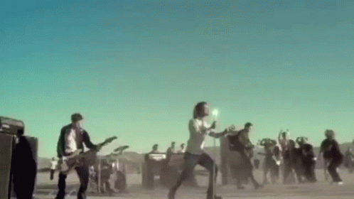A Group Of People Are Playing Guitars And Singing In Front Of A Crowd . GIF