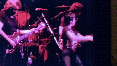 A Group Of People Are Playing Guitars And Singing On Stage . GIF