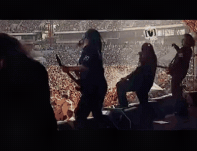 A Group Of People Are Playing Guitars In Front Of A Crowd . GIF