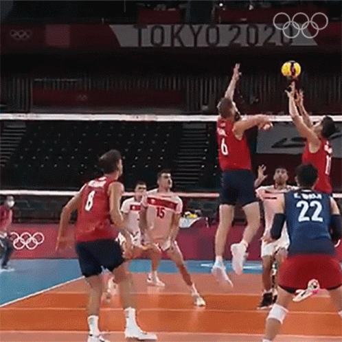A Group Of People Are Playing Volleyball On A Court . GIF