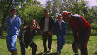 A Group Of People Are Posing For A Picture In A Grassy Field GIF