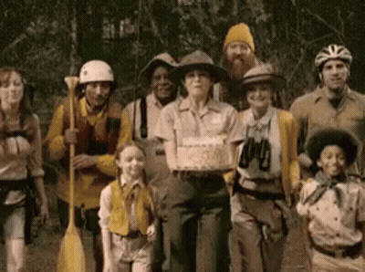 A Group Of People Are Posing For A Picture With A Woman Holding A Cake GIF