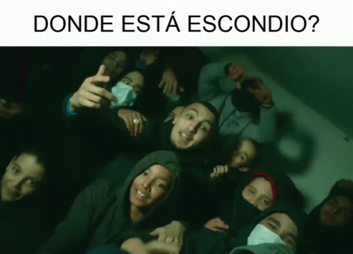 A Group Of People Are Posing For A Picture With The Words " Donde Esta Escondido " Above Them GIF